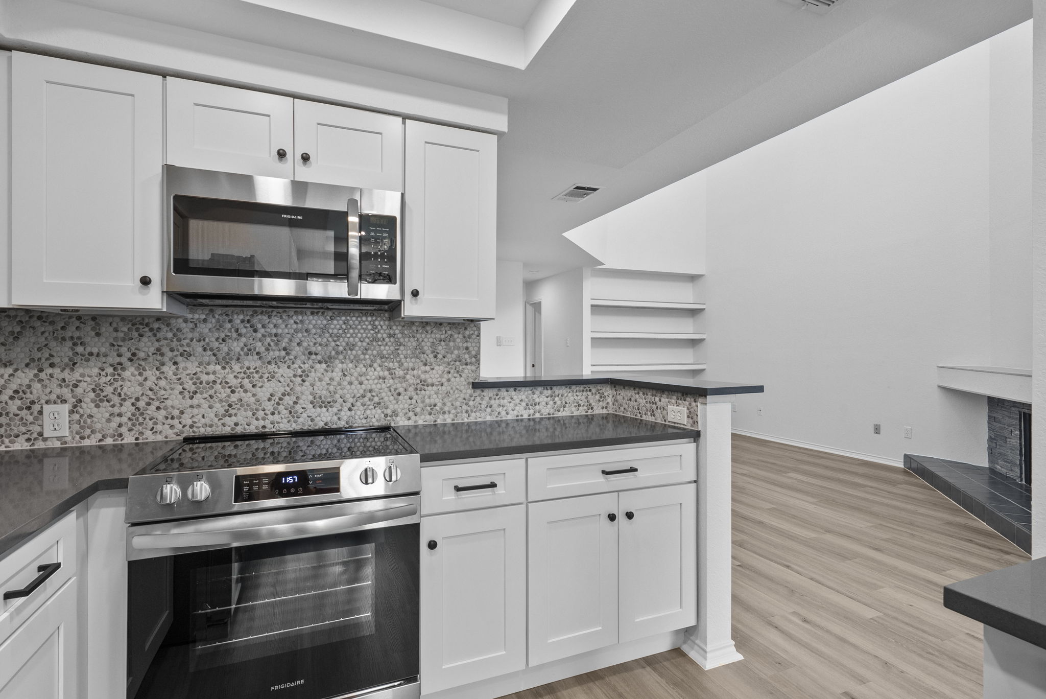 Newly updated with new white shaker cabinets and hardware, new appliances, sink & faucet, gray quartz countertops and backsplash.