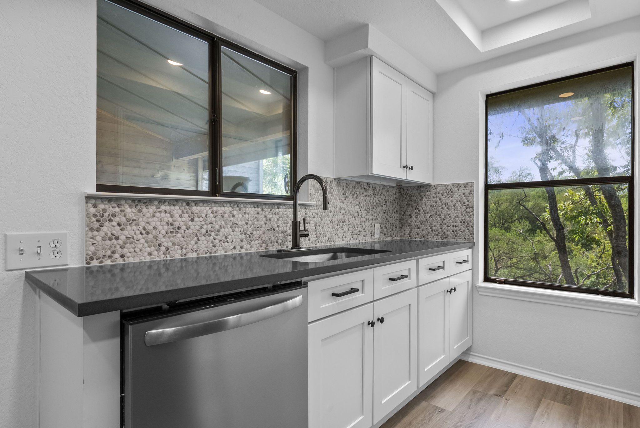 Newly updated with new white shaker cabinets and hardware, new appliances, sink & faucet, gray quartz countertops and backsplash.