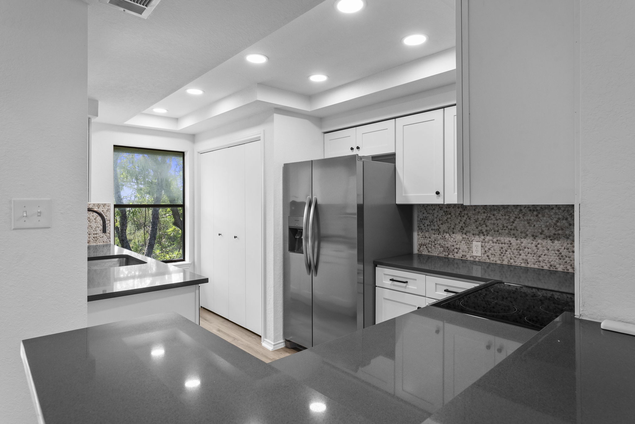 Newly updated with new white shaker cabinets and hardware, new appliances, sink & faucet, gray quartz countertops and backsplash.