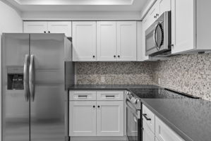 Newly updated with new white shaker cabinets and hardware, new appliances, sink & faucet, gray quartz countertops and backsplash.