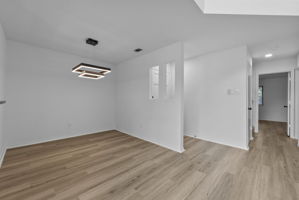 The dining area is next to the entry door. The primary bedroom is through the doorway.