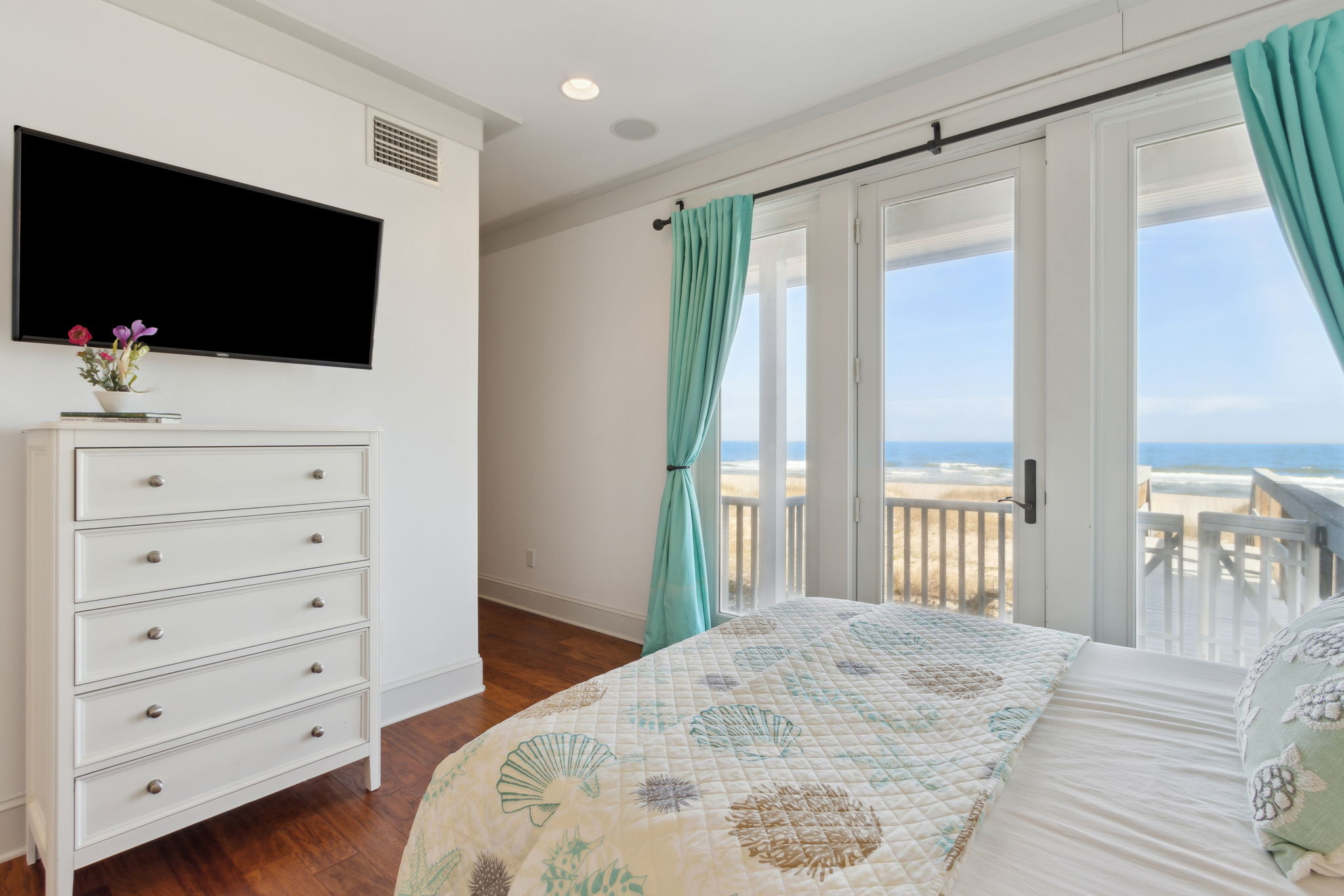 ... all bedrooms are generous in size, this one featuring two double beds, oceanfront views and balcony access...