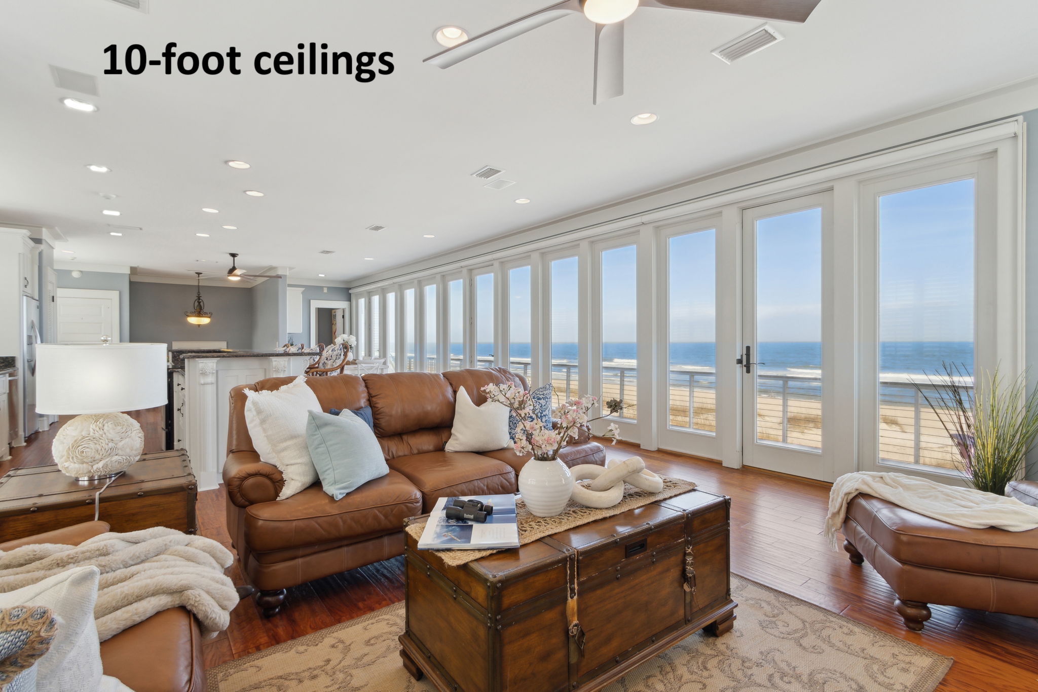 The main living area on the third floor showcases a breathtaking wall of floor-to-ceiling glass doors ...