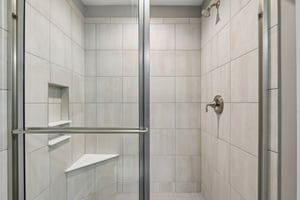Large walk-in tiled shower adds a luxury touch to the owner’s bath.