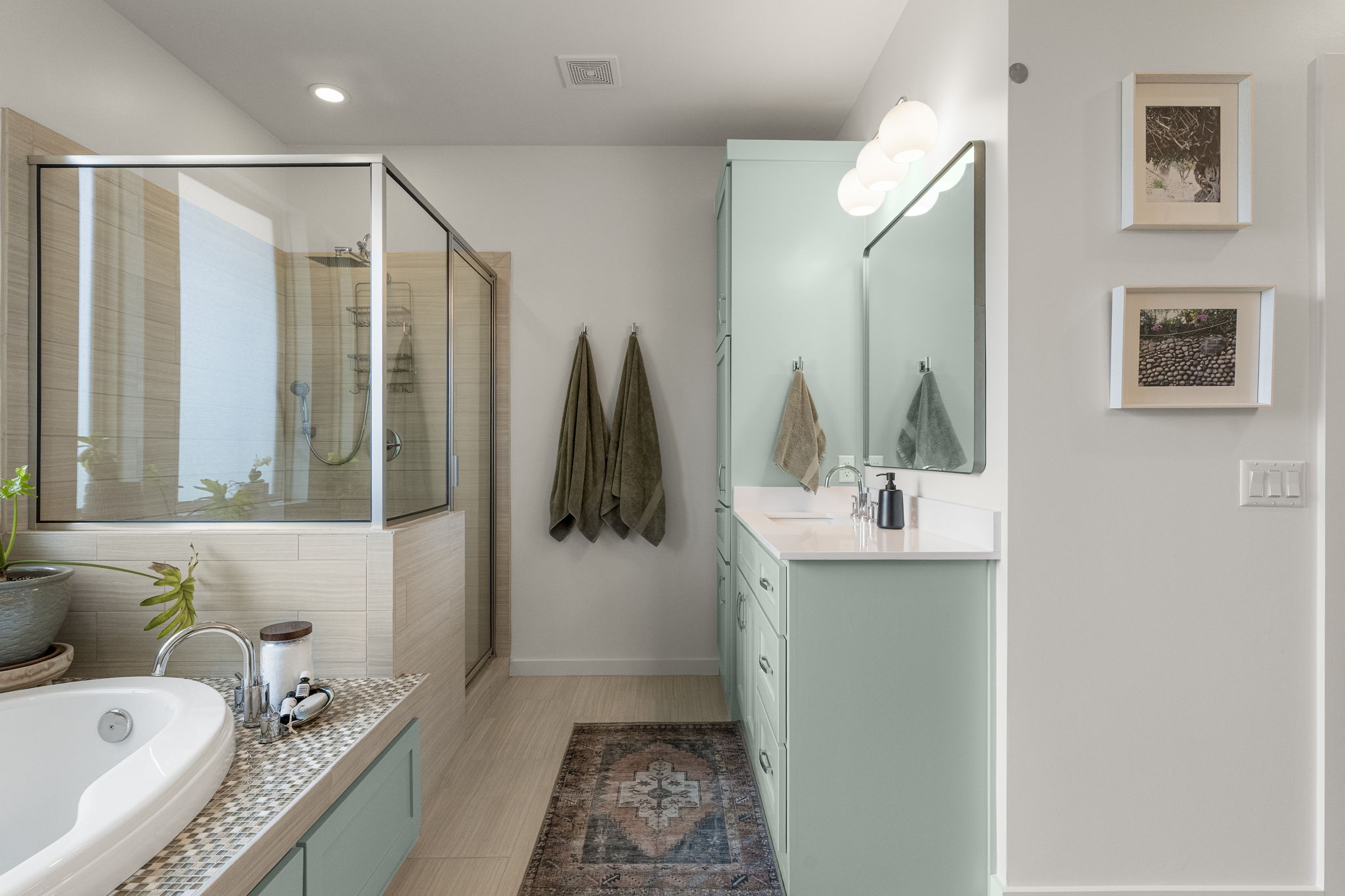 Designed for both comfort and functionality, the primary bath features split dual vanities, a walk-in shower, and a spacious soaking tub.