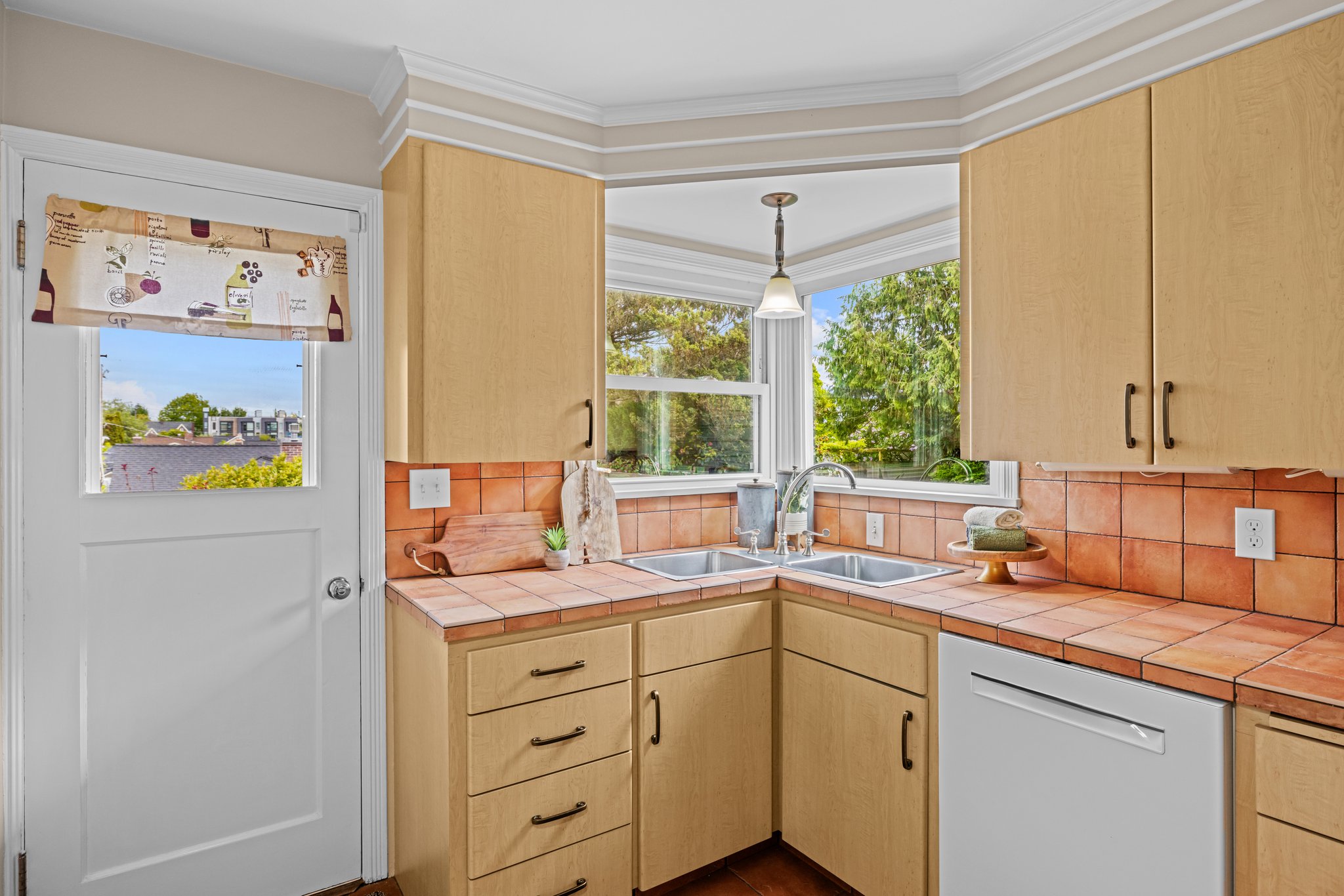Love the corner window and sink overlooking your backyard sanctuary