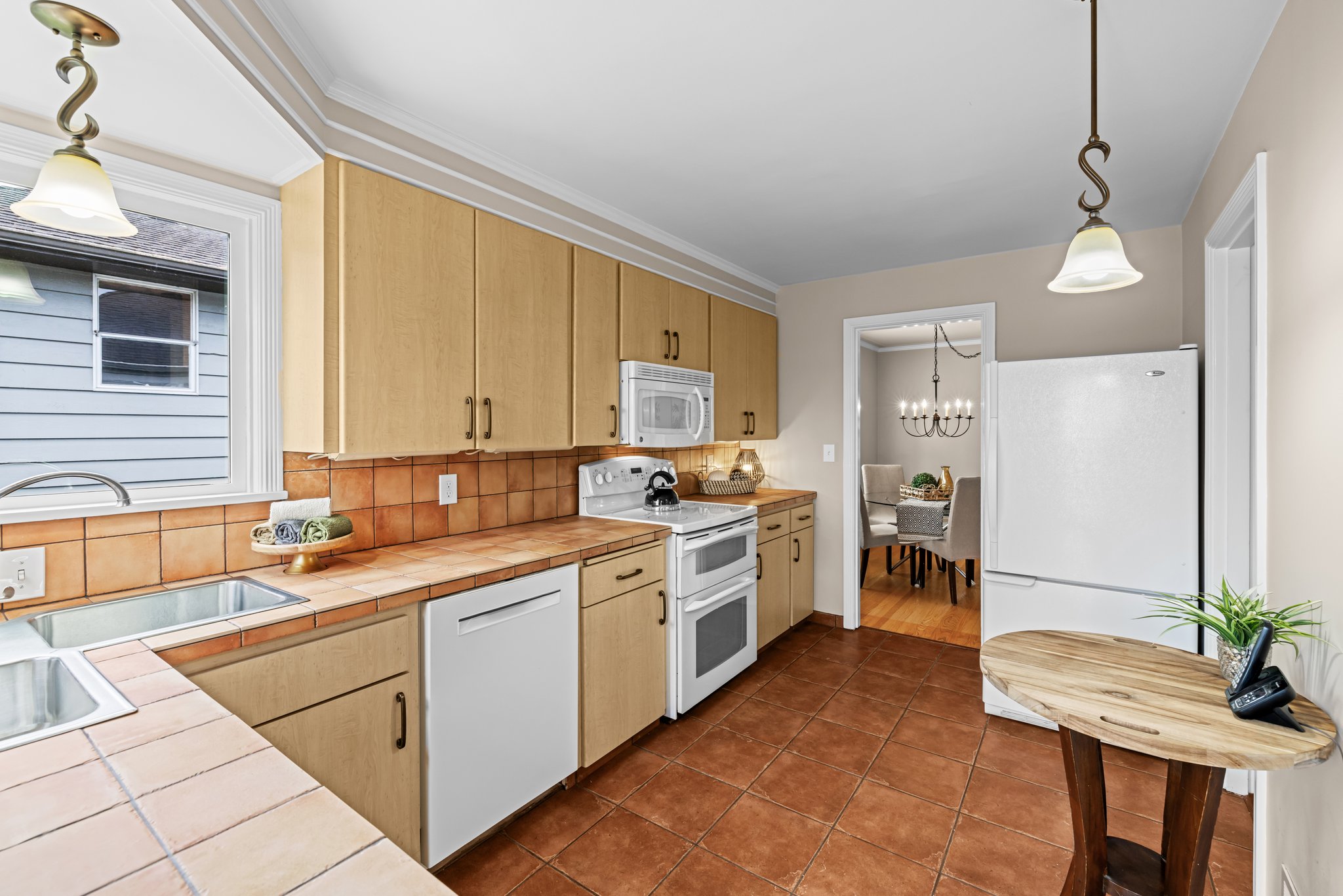 "Step into a kitchen where 1940s charm meets thoughtful updates—modern appliances complement original craftsmanship, while the corner window above the sink offers a peaceful view and a touch of nostalgia."