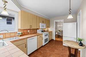 "Step into a kitchen where 1940s charm meets thoughtful updates—modern appliances complement original craftsmanship, while the corner window above the sink offers a peaceful view and a touch of nostalgia."