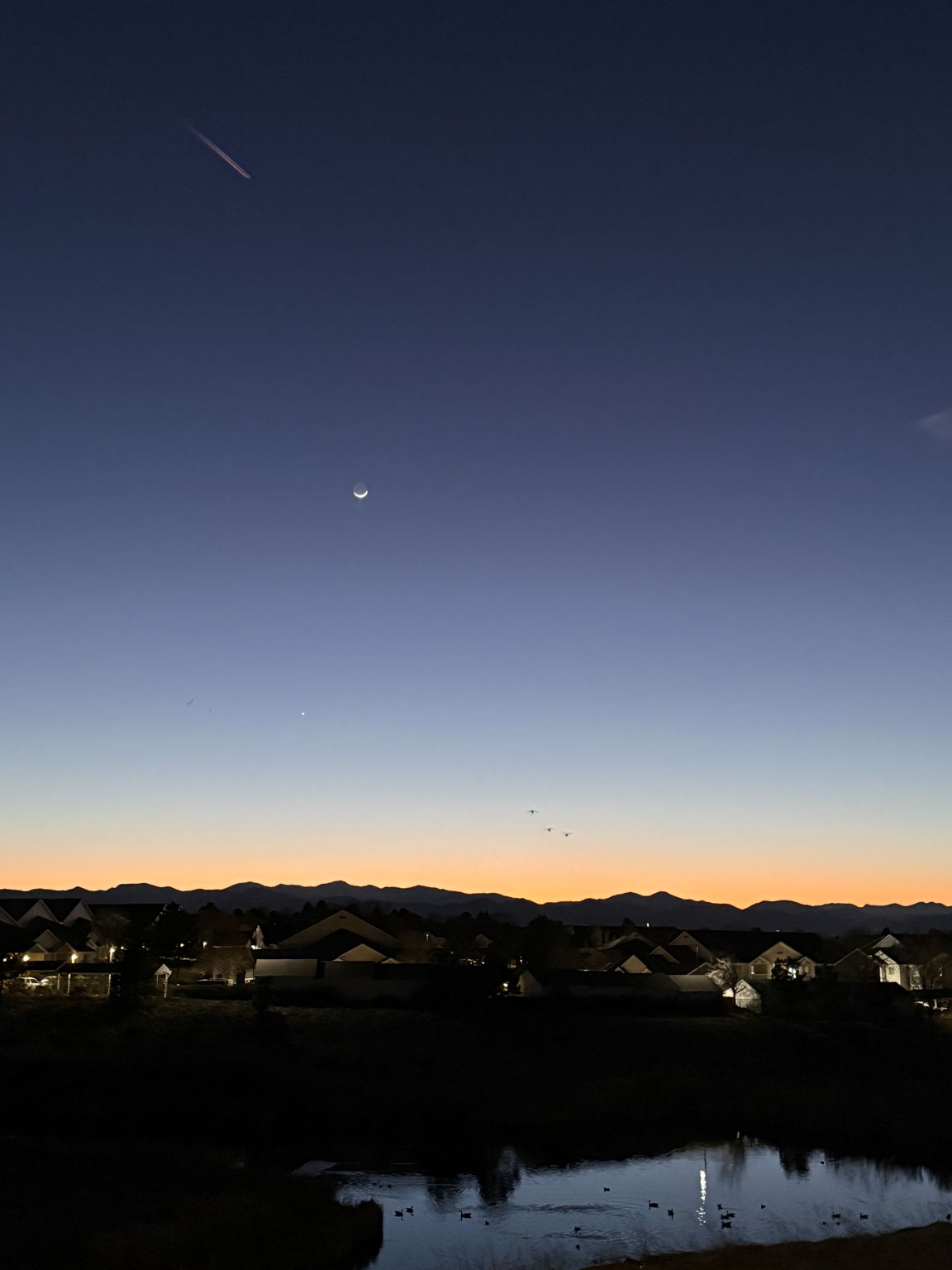 Imagine watching the sunset with a jet in the sky, crescent moon, Venus (black dot below moon) and 3 ducks coming in for a landing on the pond