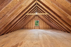 Over the garage, exposed rafters and open unfinished space invite a fresh perspective. Separate entrance from the firepit patio.