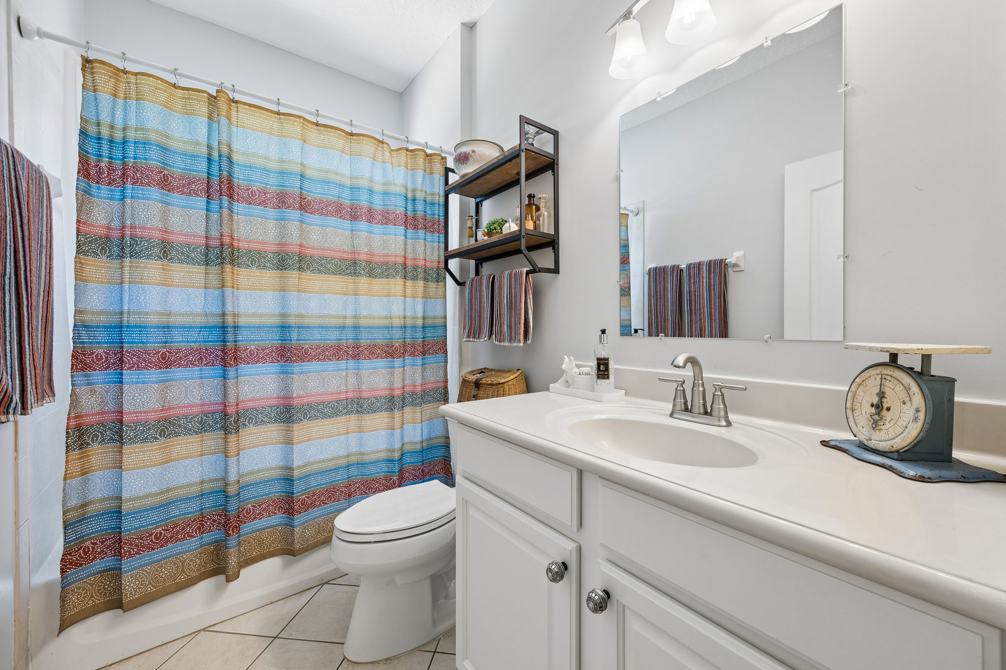 Third bathroom features tiled tub and shower combination.