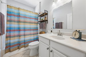 Third bathroom features tiled tub and shower combination.