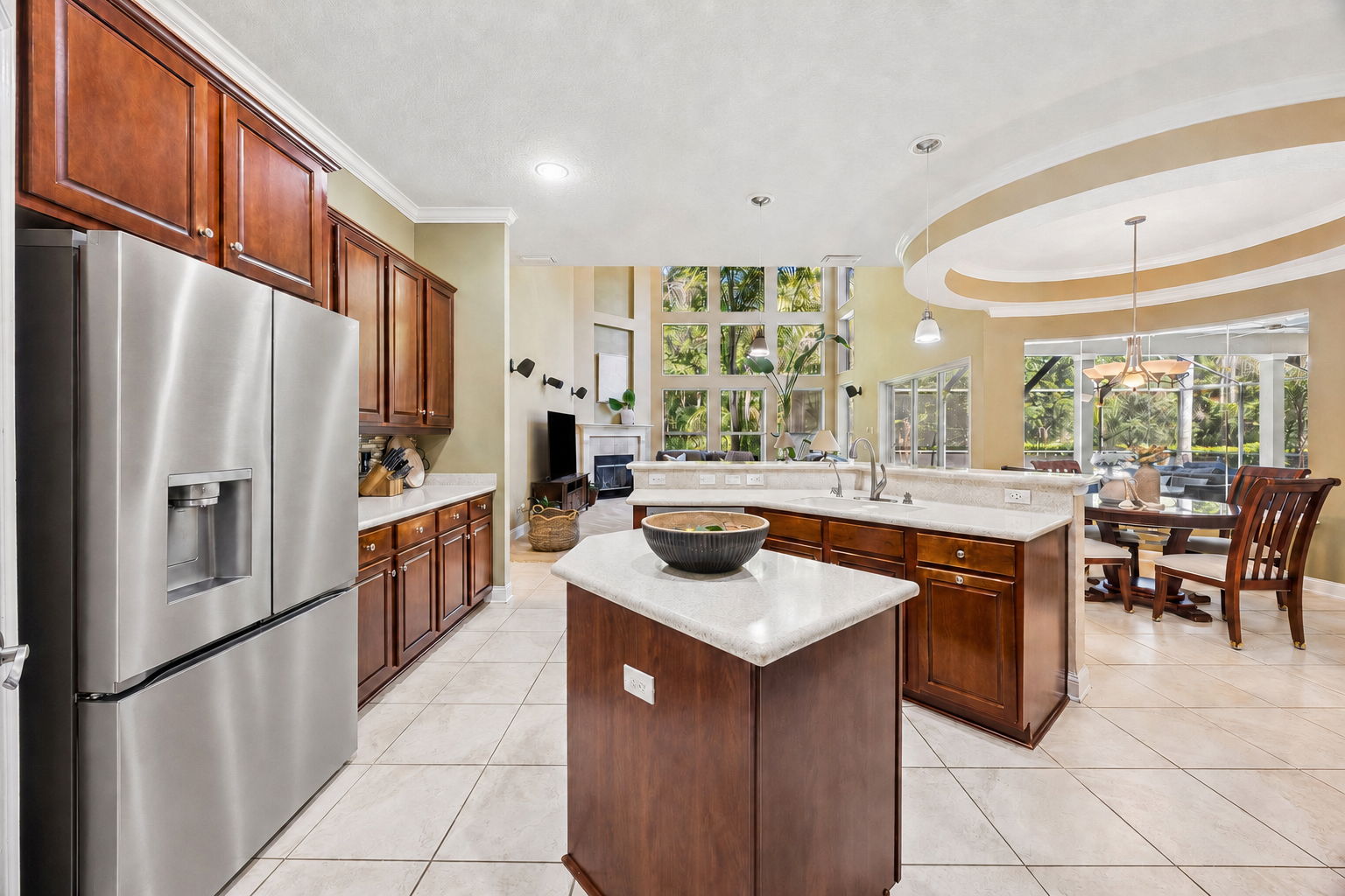 The kitchen opens naturally to the family room, breakfast area, and pool views beyond …