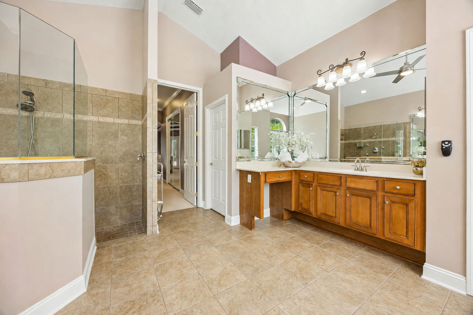 … while a long counter, built-in makeup station, and ample cabinetry make the room highly functional