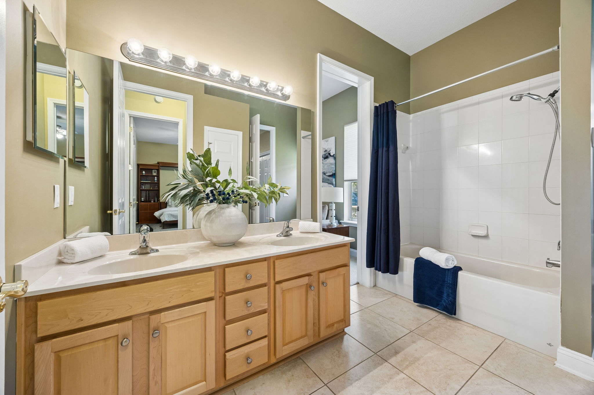 The shared bath includes dual sinks, generous cabinetry, and a tub-shower combination between the two guest rooms ...