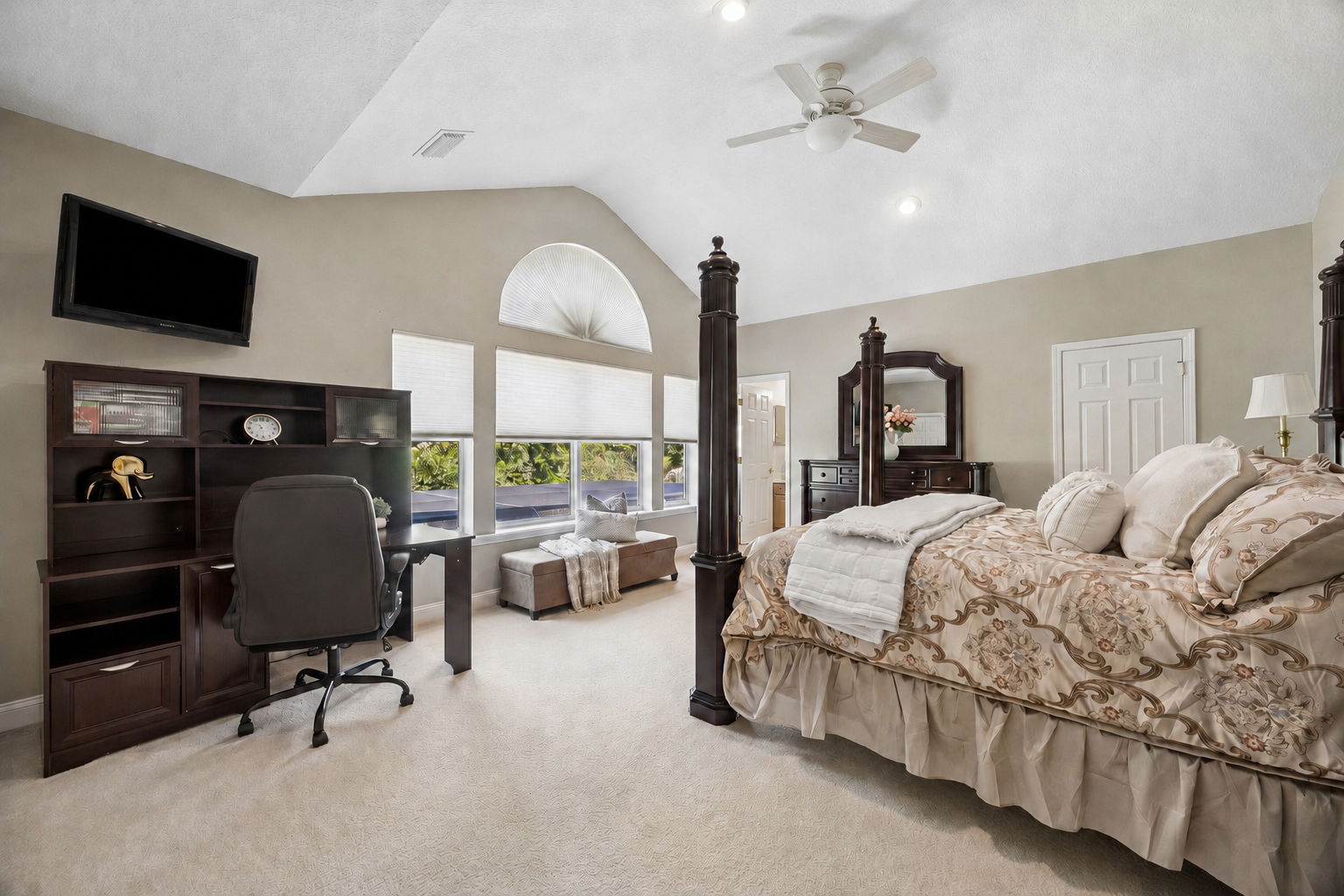 The second-floor bedroom offers a private retreat off the loft, with vaulted ceilings, arched windows, and views overlooking the pool area ...