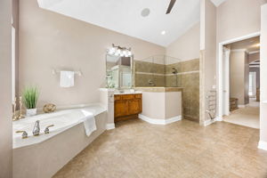 The primary bath is spacious and well arranged, with a soaking tub, glass-enclosed shower, and separate vanity areas ...