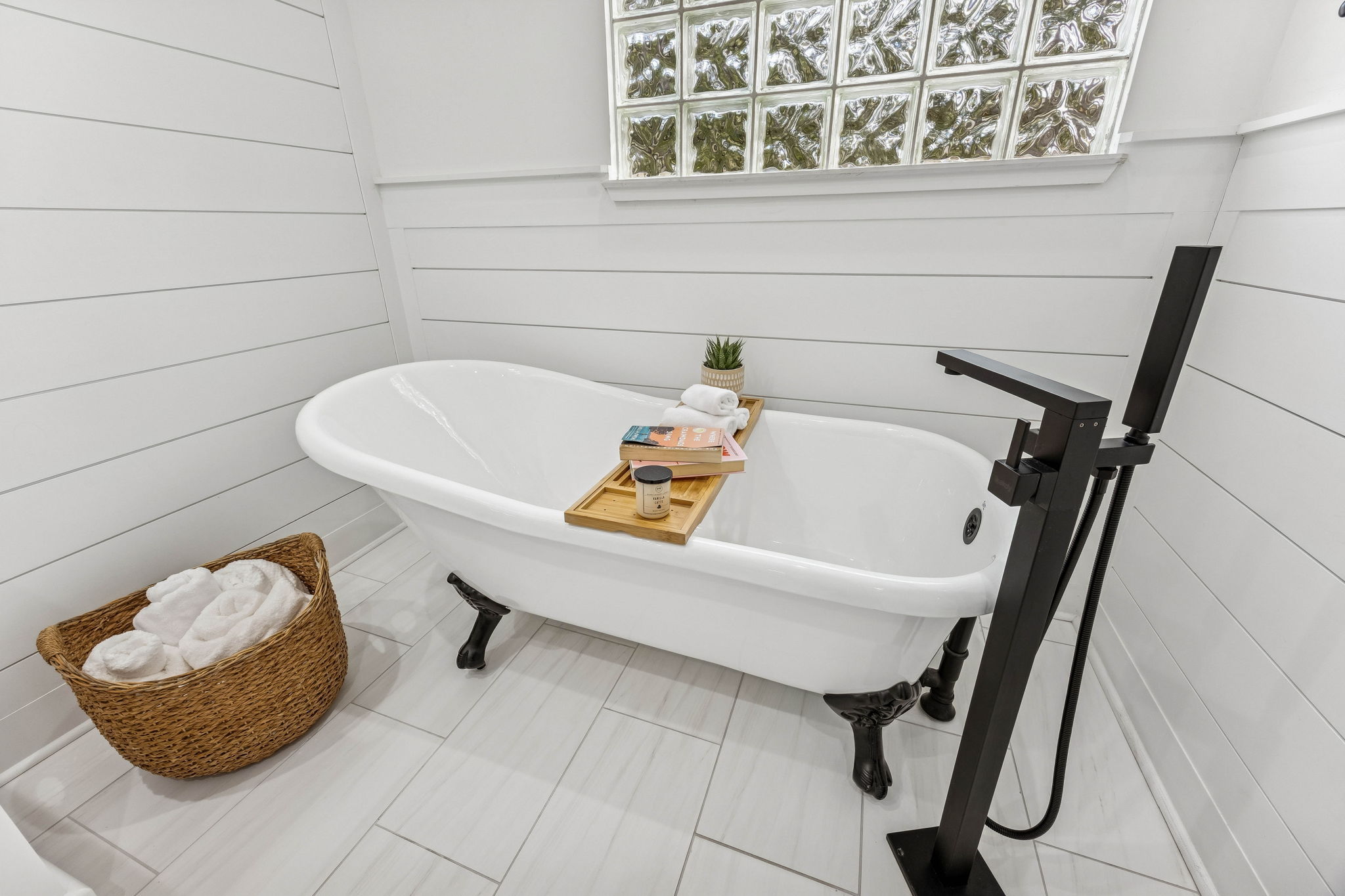 ... like a sculptural freestanding soaking tub beneath glass block windows, creating the perfect place to unwind