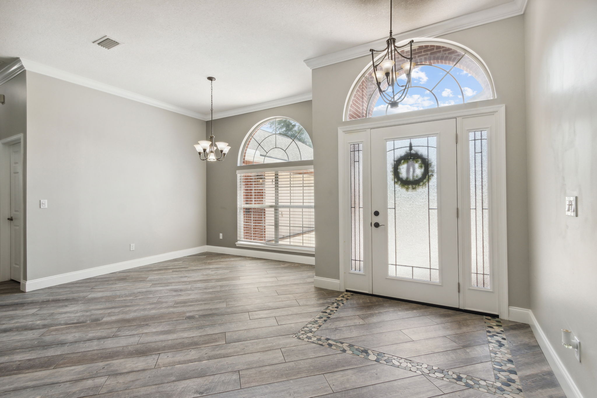 The grand front entry door features sidelights and arched transom windows