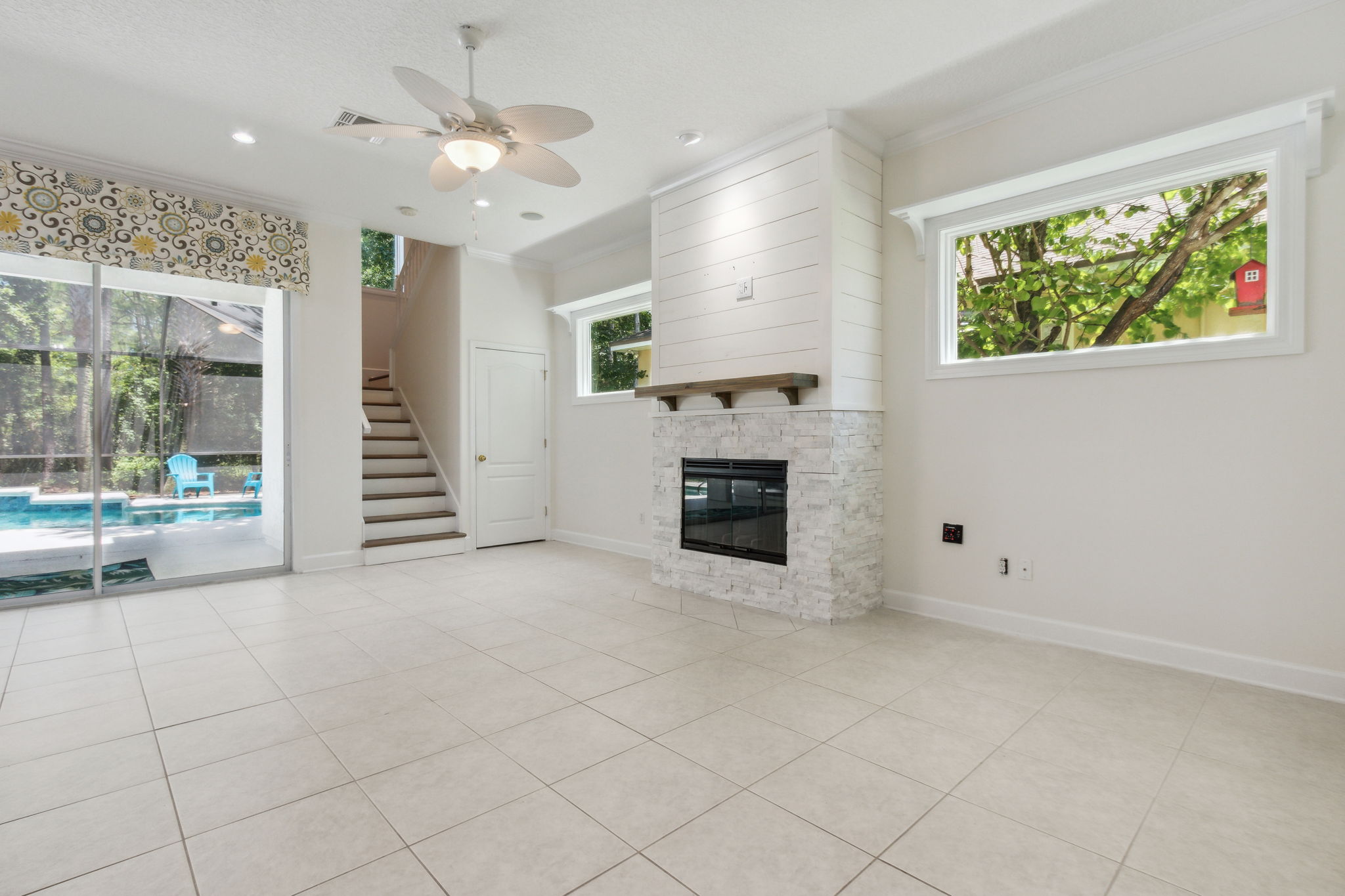 Gathering room featuring abundant natural light and new tile and shiplap fireplace surround.
