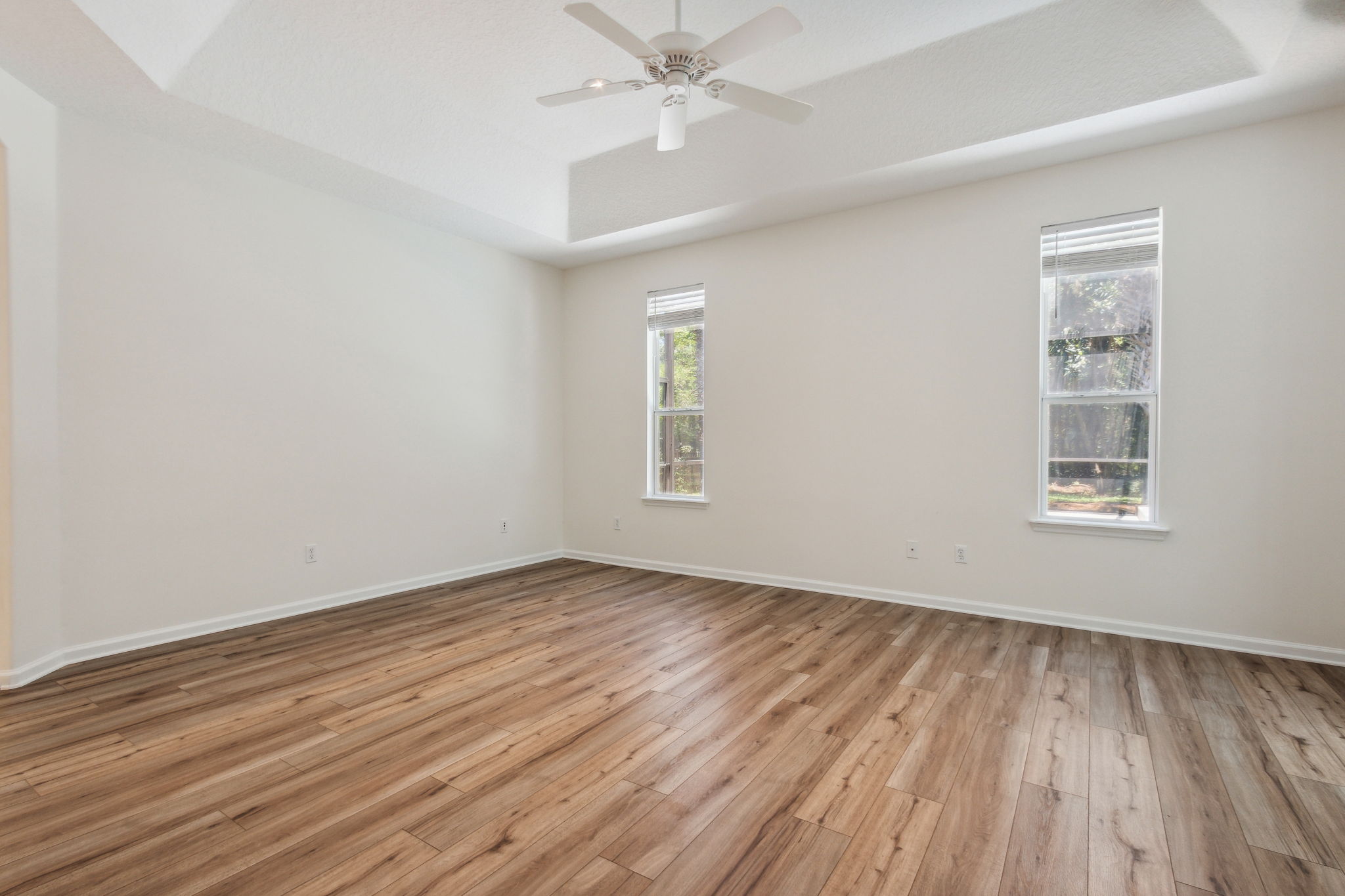 Primay suite with tray ceiling and serene views of the preserve and pool.