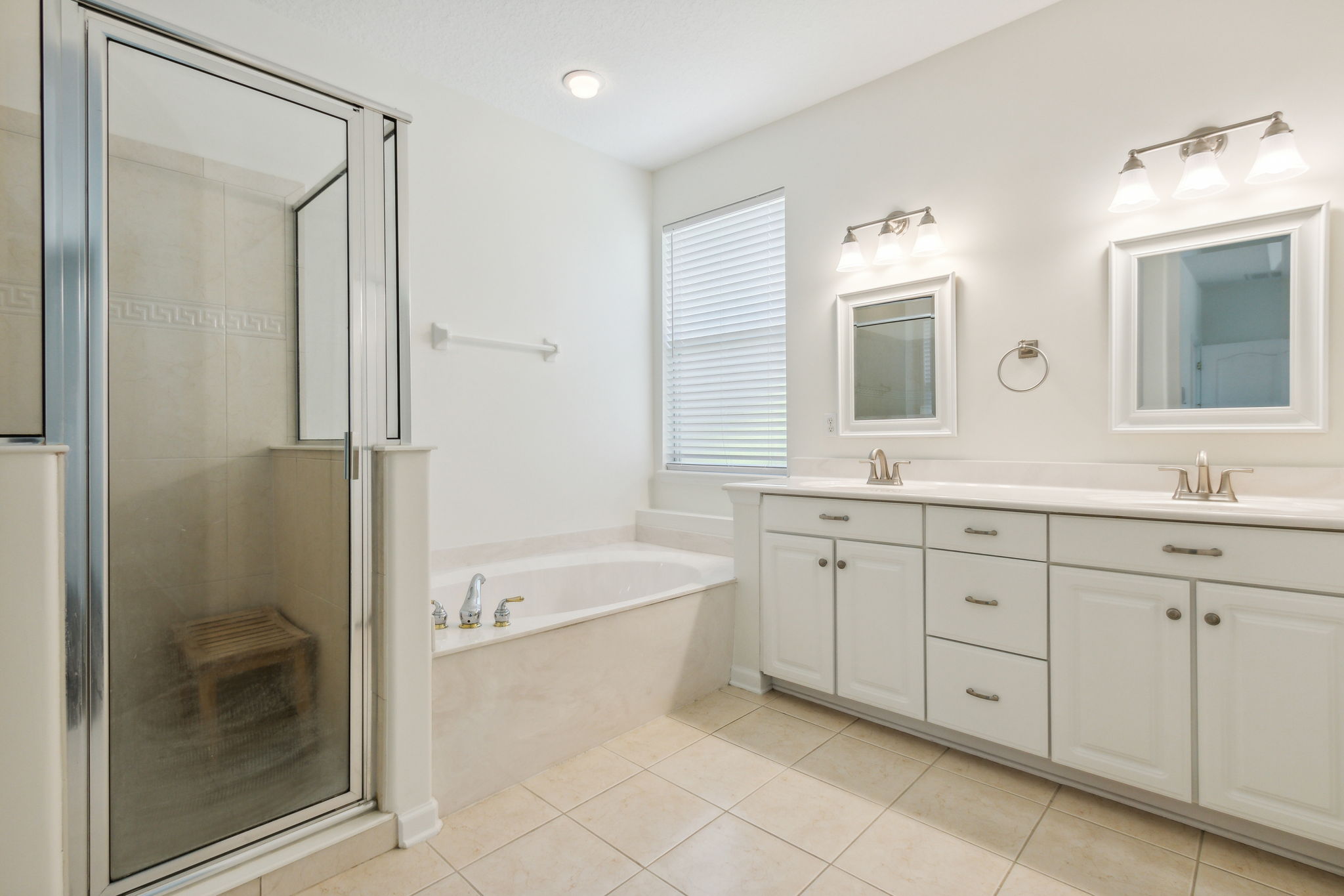 Primay bathroom with dual sinks, separate shower and tub