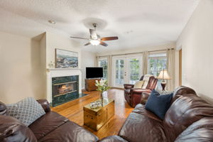 The family room is anchored by a gas fireplace and framed by a wall of glass ...