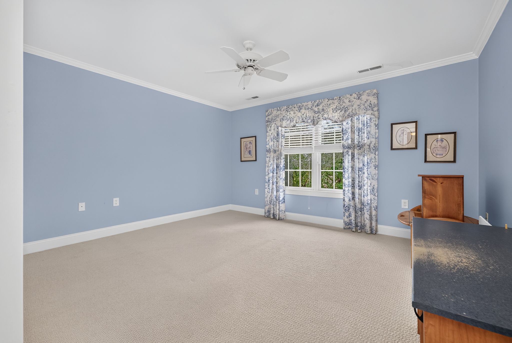 BEDROOM 2 Crown moulding, ceiling fan , double slider closet, and carpeting.