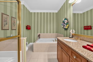 EN SUITE BATH Features of the private bath include an upgraded wood vanity with make up counter and double sinks, mirrored medicine cabinet, soaking tub, seated shower, and ceramic tile flooring.