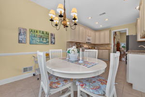 The eat-in kitchen is appointed with upgraded cabinetry, 42-inch upper cabinets, granite countertops, a tum-bled tile backsplash, and quality appliances.