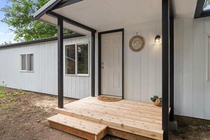 New T1-11 siding, windows, roof on home/shed, and adorable new covered front deck.