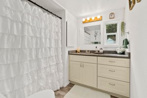New cabinets and counters in bathroom, built in shelf, and window.