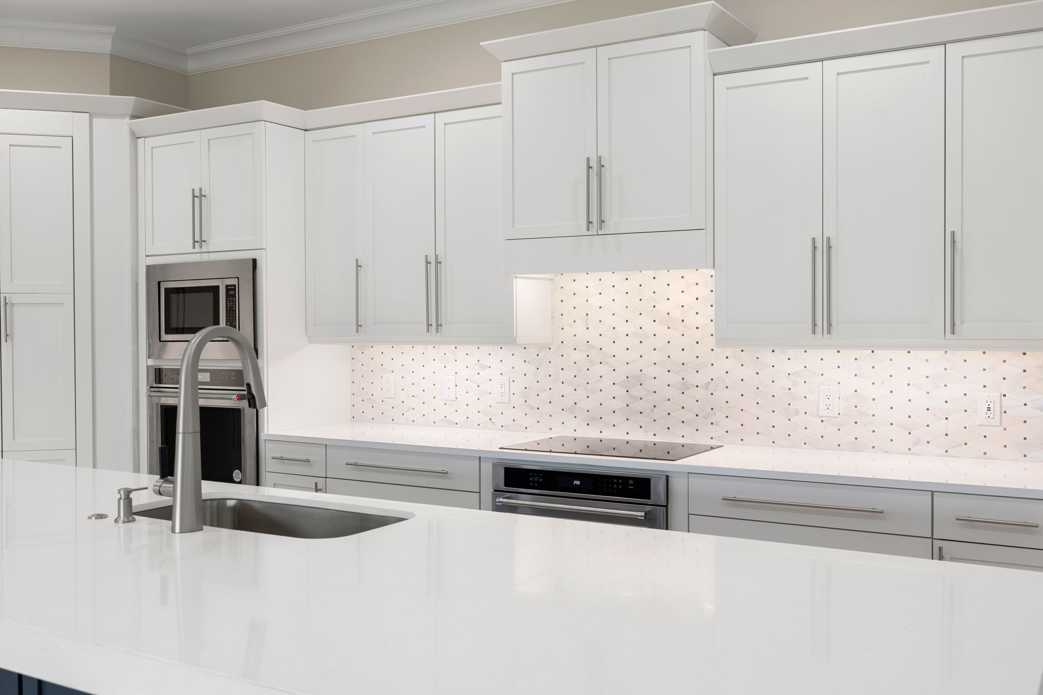 Soft close shaker cabinetry, quartz countertops, stainless GE appliances featuring double ovens and custom tile backsplash