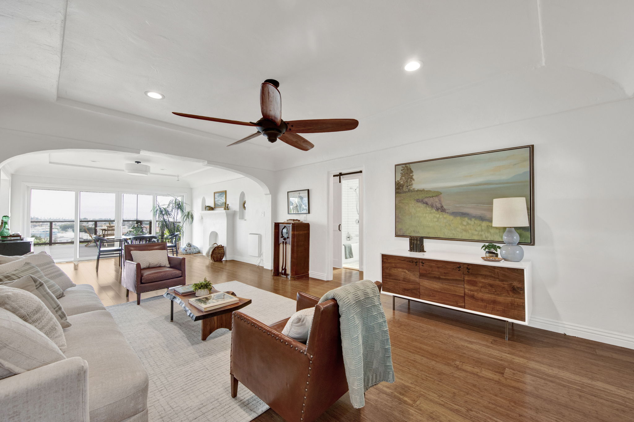 Wide view of living and dining area with original plaster archways San Pedro Spanish bungalow