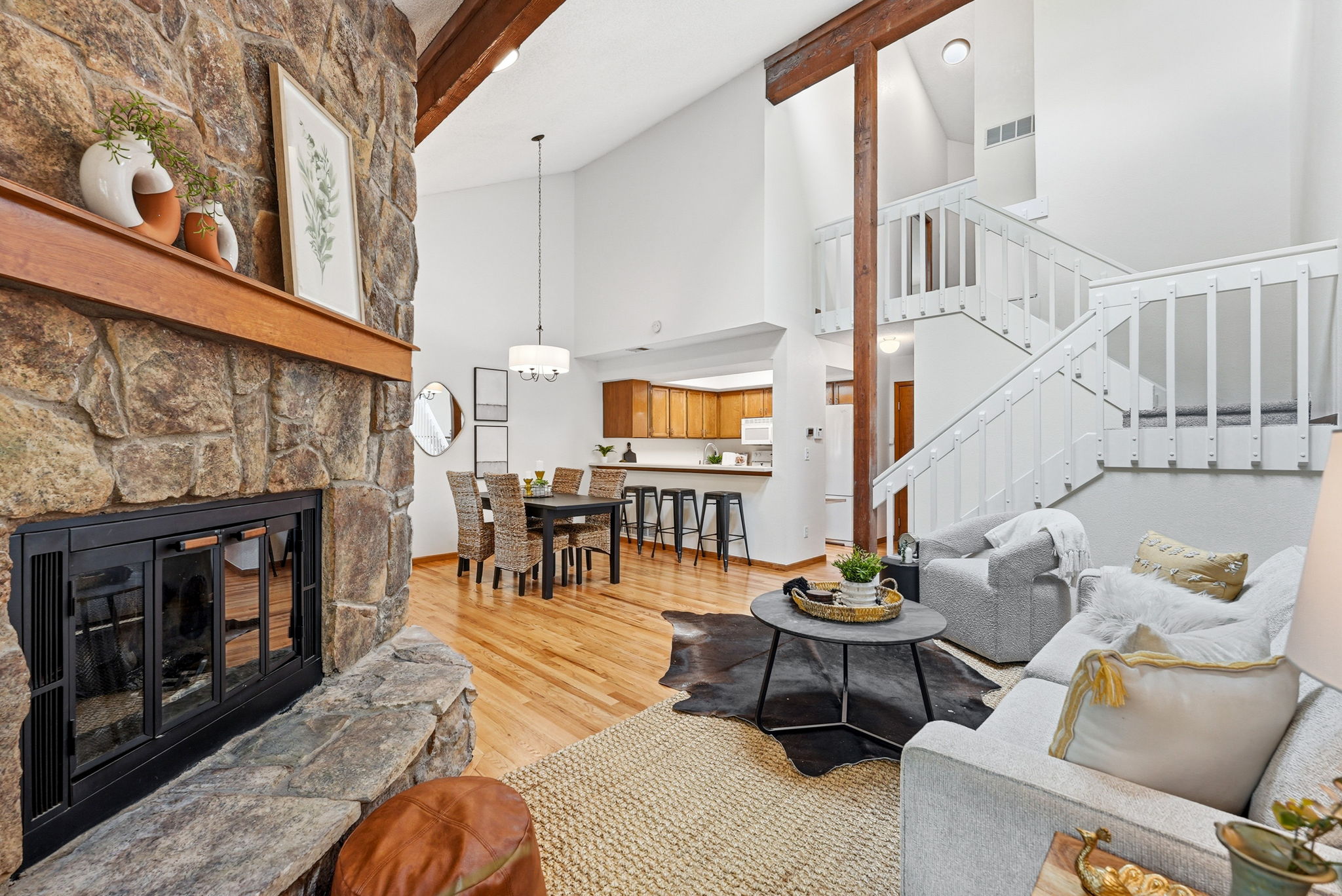 Living Room with Vaulted Ceilings, Exposed Beam, Wood-Burning Fireplace, Real Hardwood Floors, Wood-Burning Fireplace, Dining Room, Kitchen with Bar Seating and New Paint Throughout