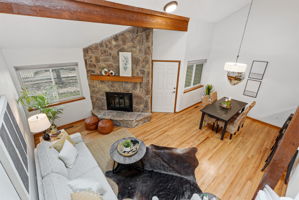 Living Room with Vaulted Ceilings, Exposed Beam, Wood-Burning Fireplace, Real Hardwood Floors, Wood-Burning Fireplace, Dining Room, Front Door to Fenced Patio  and New Paint Throughout