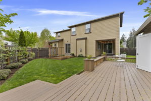 Scenic views from the custom shop deck overlooking garden beds and thoughtfully planted apple trees and grapevines
