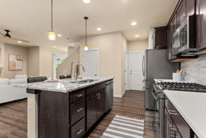 Enhanced kitchen with upgraded countertops, elegant cabinetry, and natural gas stove