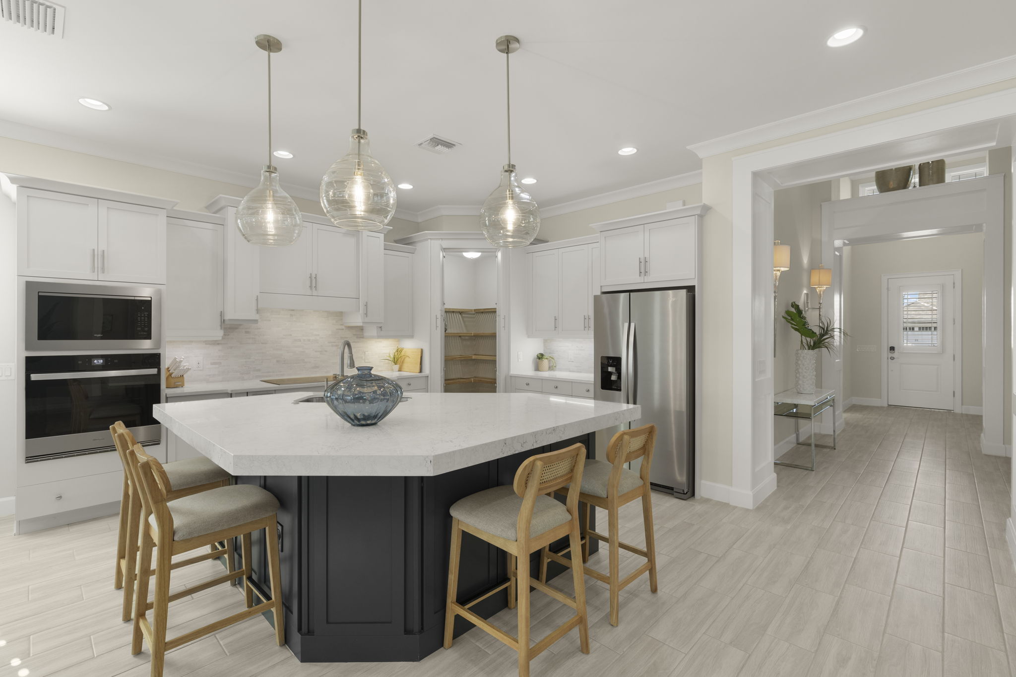 Kitchen with expansive island and walk-in pantry. Soft close, shaker cabinetry, stainless appliances.