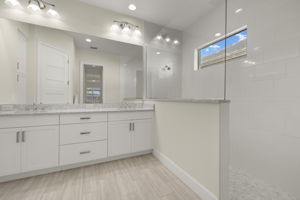 Primary Bathroom with dual sinks, frameless shower