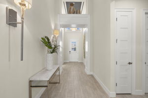 Dramatic foyer with vaulted ceilings, custom lighting, sconces