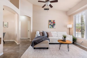 Inviting living room with vaulted ceilings and neutral ceramic tile throughout the whole home.