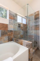 Slate tiled walk in shower with glass doors.