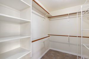 Walk in closet with built in shelves and hanging space.