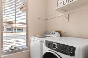 Laundry room with top load washer and front load dryer.
