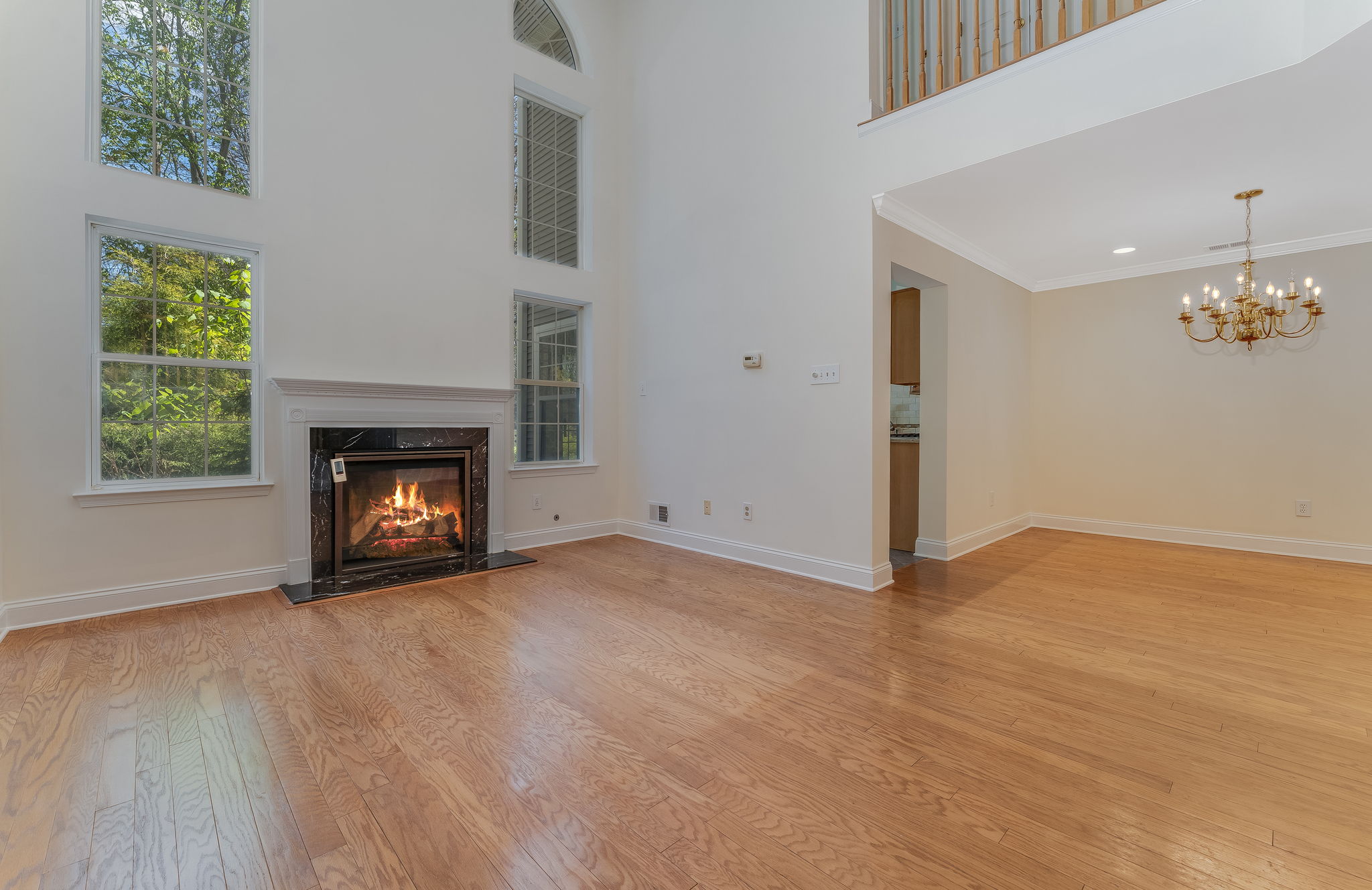 A gas fireplace with a classic mantel adds warmth and visual appeal to the great room. Oversized windows fill the open, airy floorplan with natural light.
