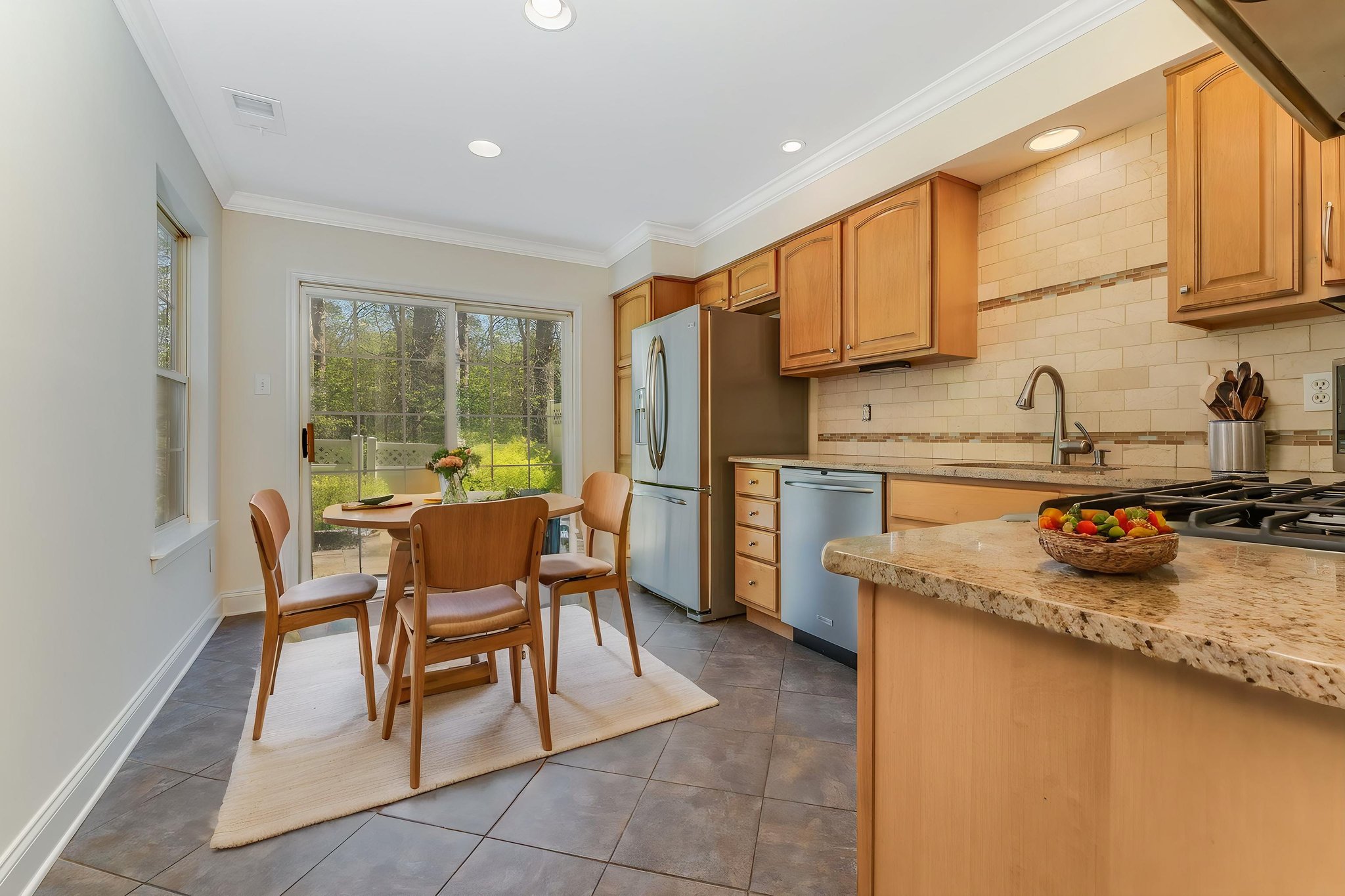 Virtually Staged. The renovated kitchen features raised-panel cabinetry with soft close drawers and pantry, granite counter tops, ceramic tile backsplash, stainless steel appliances, and ceramic tile floor.