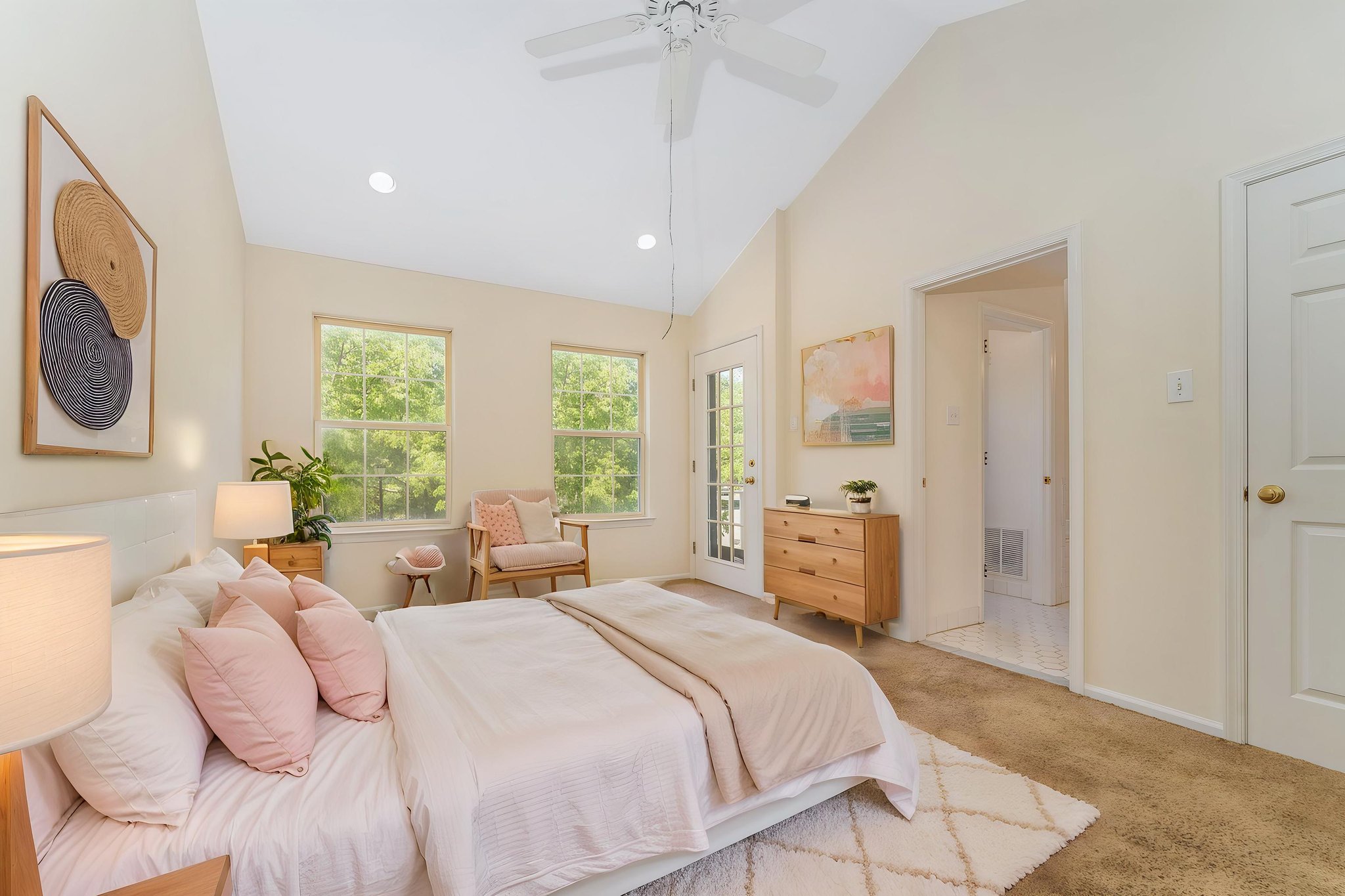 Virtually Staged. The primary bedroom features a cathedral ceiling, recessed lighting, ceiling fan, walk-in closet, and neutral carpeting, with direct access to a private deck.