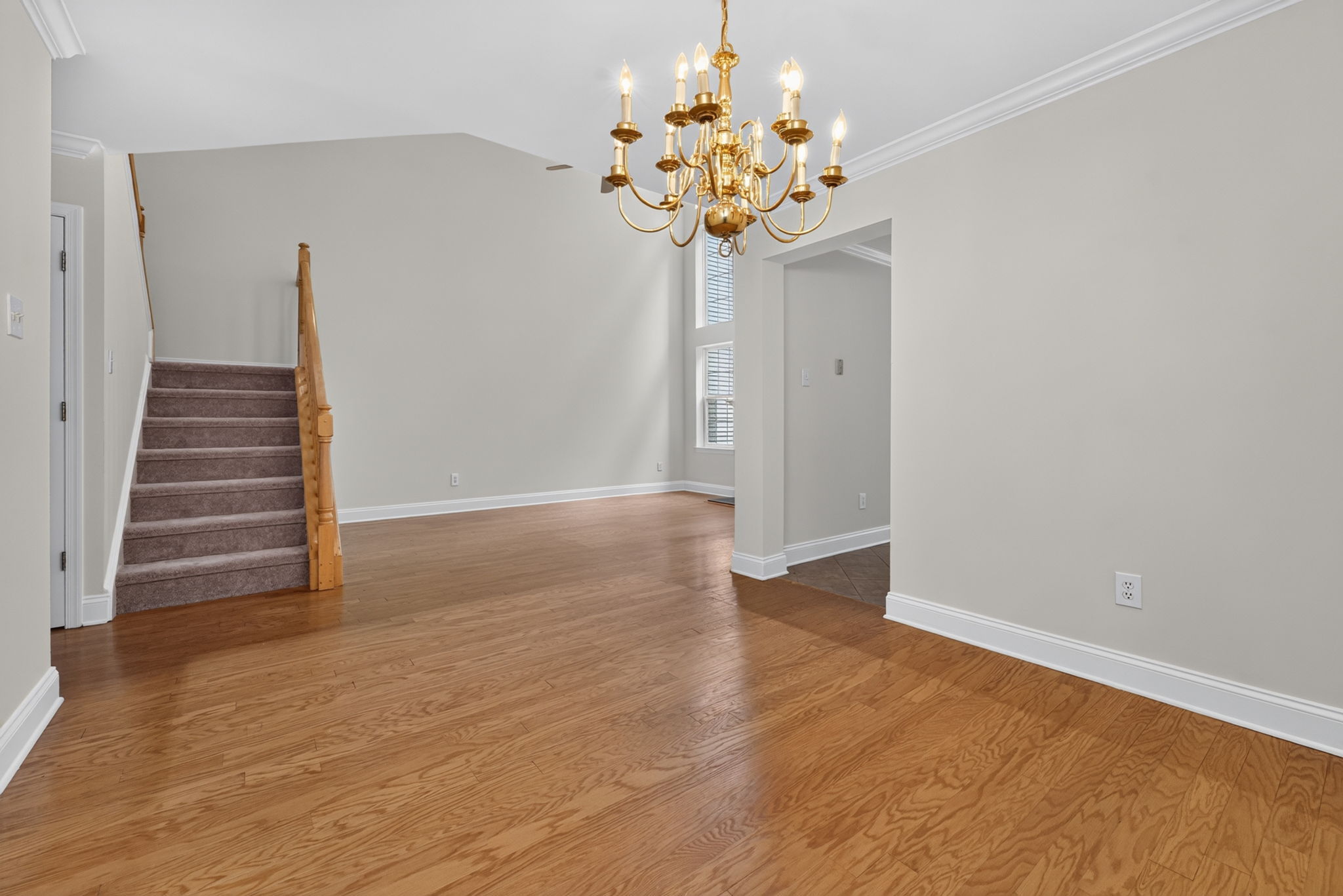 Hardwood flooring flows from the foyer into the dramatic two-story great room and formal dining room, highlighted by crown moulding.   Stairway with NEW CARPETING!