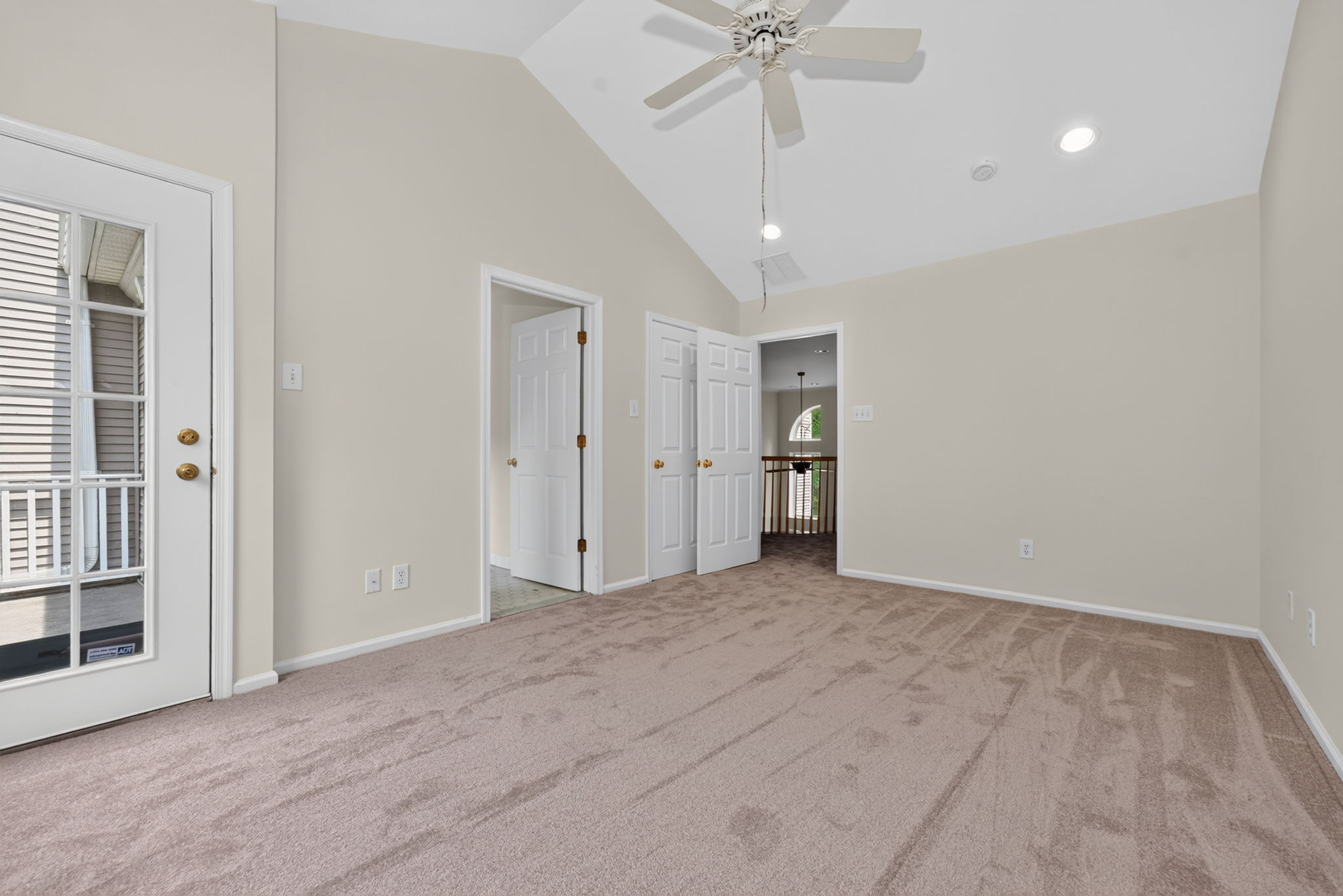 The primary bedroom features a cathedral ceiling, recessed lighting, ceiling fan, walk-in closet, and NEW CARPETING, with direct access to a private deck.